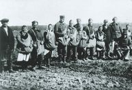 Gruppenbild von Landarbeitern auf dem Feld, u.a. zu erkennen: Männer in belgischen und französischen Uniformen, vermutlich Kriegsgefangene. Landgut Berlin-Buch, März 1943